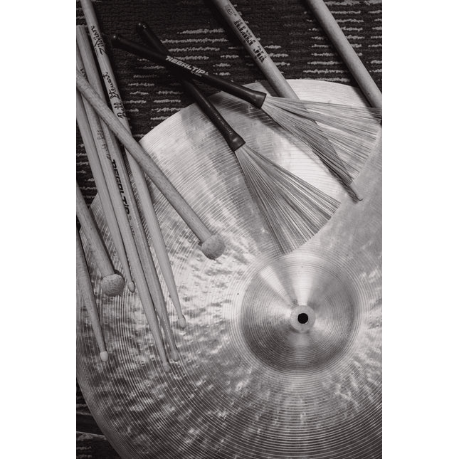 Drumsticks, brushes and a cymbal, black and white