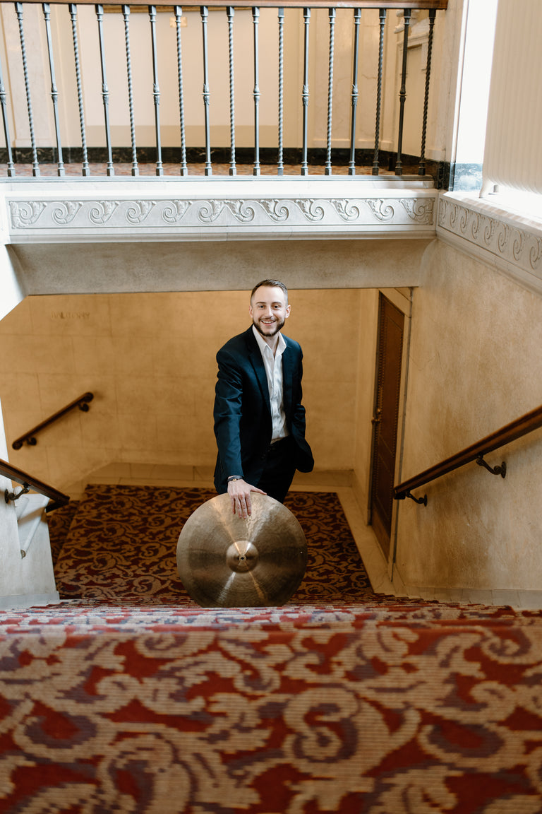 Jazz drummer Ryan Barski leaning on his cymbals